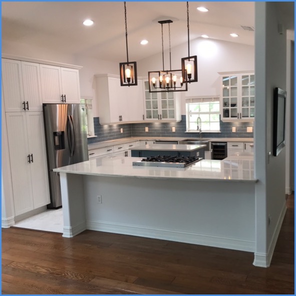 Custom kitchen remodel by Strong Tower Carpentry — vaulted ceilings, marble island, white shaker cabinets