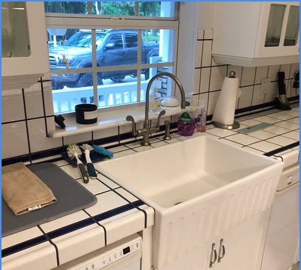Farmhouse apron sink with custom subway tile counter and goose-neck faucet